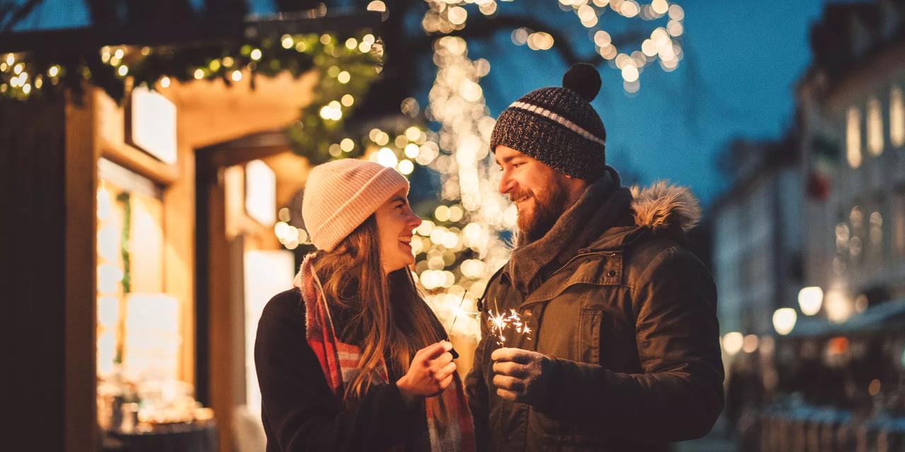 mann og kvinne smiler til hverandre p&aring; julemarked